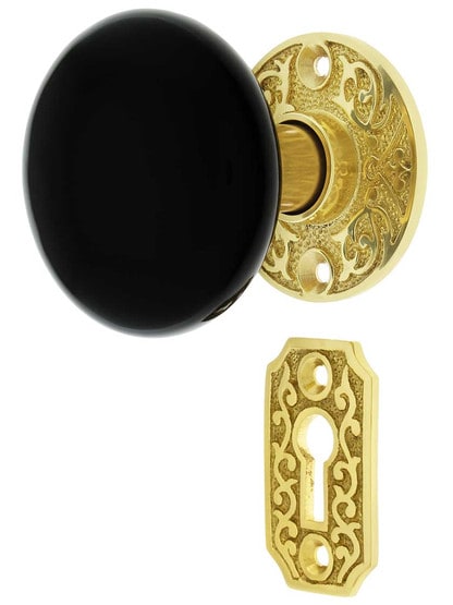 Scroll Rosette Mortise Lock Set with Black Porcelain Door Knobs in Polished Brass.